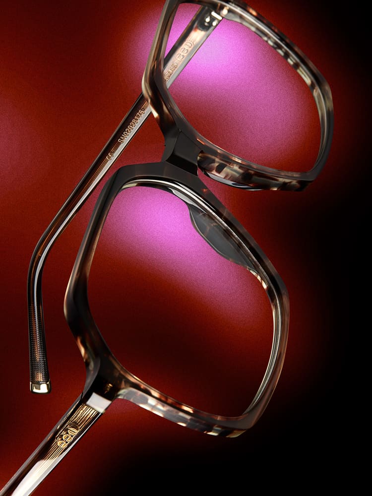 Gemusterte Acetatfassung vor rotem Hintergrund